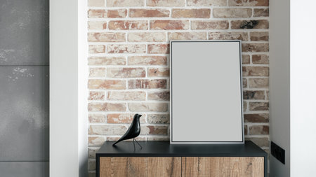Cropped shot of wooden commode with mock up picture in frame next to shiny artificial bird against...
