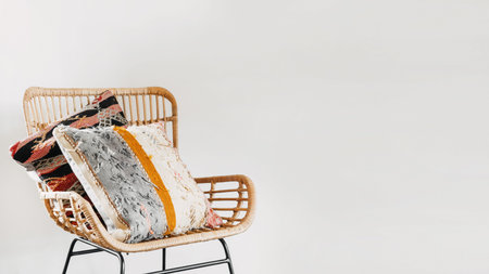 Bamboo chair with ethnic cushions in living room with home decor and boho interior design. Rattan...