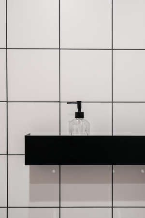 Closeup at bathroom shelf, modern shower cabin. Clean bath with soap, shampoo, beauty product in bottle. Shower lotion liquid in transparent case. Treatment product at white wall.の写真素材