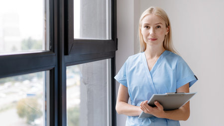 Healthcare concept. Confident assistant of doctor standing in hall at private clinic, wearing in...