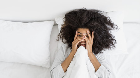 Top banner view of happy and smiling young afro american woman waking up, peeking through fingers,...