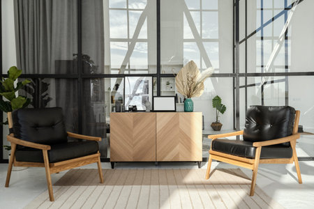 Two black chairs stand side by side near wooden table. New office with panoramic windows. Bright and...