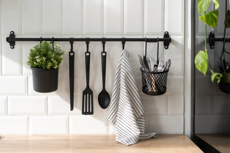 Classic style kitchen interior appliances and towel hanging on wall. Contemporary decorations for cozy dining room. Black cutlery bundle conceptの写真素材
