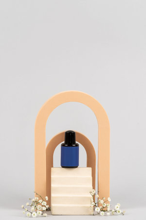 Mockup of small sample bottle with beauty cosmetics stand on top of podium against light background with copy space. Advertising concept of travel package for shampoo, shower gel on hair conditionerの写真素材