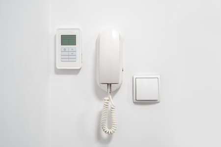 Light switch, intercom and alarm on white wall in modern flat. Home safety concept. Smart luxury house. Modern technologies for apartments. security equipmentの写真素材