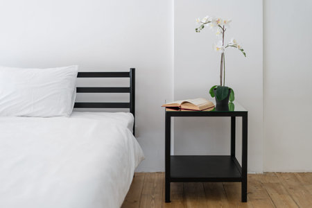 Cropped view of minimalistic style bedroom interior design with white lines. Black bedside table...