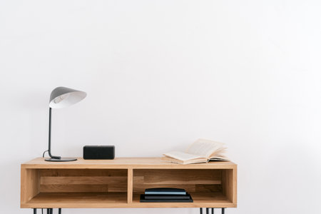 Lamp, open book and music column on wood table near white wall. Modern room interior design. home office concept. home comfort. Comfortable workplaceの写真素材