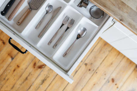 storage concept or cutlery drawer with silver ware, spoon, fork, knife and utensils at modern home kitchen, top viewの写真素材