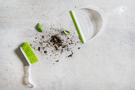 top view of plastic broom with green bristles and soil garbage on tile floor in house, cleaning and sweeping conceptの写真素材
