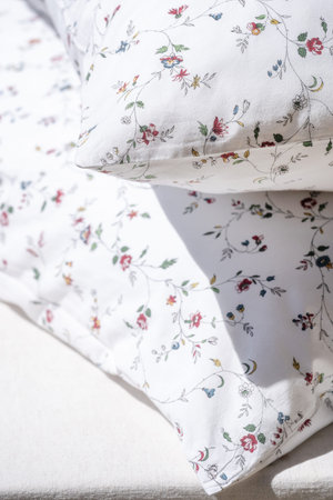 beautiful bed linen with floral decor and soft comfort cushions on bed in bedroom, dry cleaning...