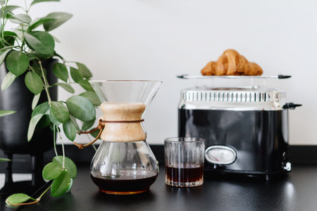 alternative method of brewing fresh coffee at home, glass with hot caffeine beverage and fresh...