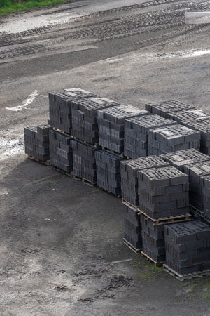 Vertical shot of wooden pallets of new produced bricks wait for shipment and delivery in a outdoors construction warehouse on the street. Concepts of repair and building materialsの写真素材
