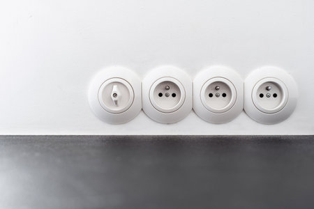 closeup of round plastic power outlet on white background, electric supply at apartmentの写真素材