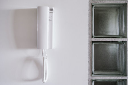 Intercom equipment on white wall. Security and communication system for opening entrance door to the...