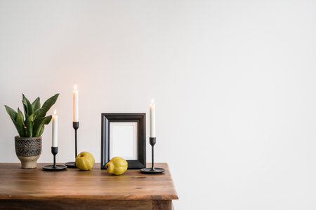 plant in ceramic pot, black metal candlestick and photo frame with empty space on dining table on white background, home decor in living roomの写真素材