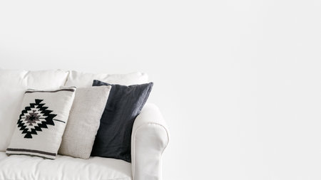 cropped shot of comfort couch with cushions in textile covers on white background with copy space, decor idea for ethnic boho design in interiorの写真素材