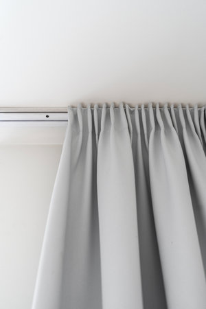 detail in cozy living room with modern interior, gray fabric curtain on ceiling track closed window and protect from sunshine, home decor elementの写真素材