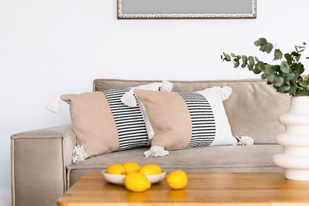 Minimalistics house with grey modular sofa and home decor on wooden table. Living room with modern...