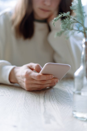 Selective focus on modern smartphone in woman hand. Female using cellphone, surfing and browsing internet, using online app, sending message, reading blogの写真素材