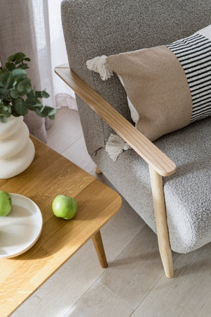 High angle view on wooden table with green apples close to comfy armchair in room. Home decor and apartment furnishing concepts. Sofa in scandinavian living spaceの写真素材