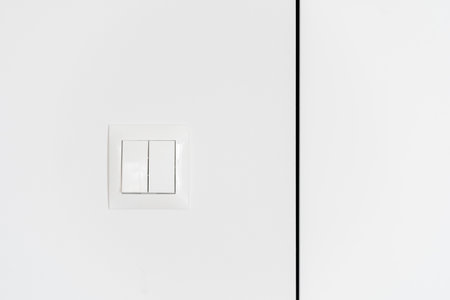 front view on contemporary plastic switch buttons at modern apartment on white background, saving electricity conceptの写真素材