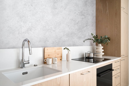 stylish apartment with wood cabinet furniture, white worktop, sink with chrome faucet, glass ceramic...