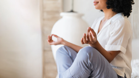 selective focus on female hand with mudra gesture while meditation in lotus pose. woman do yoga practice at home. wellbeing and stress relief concept. mindfulness lifestyleの写真素材