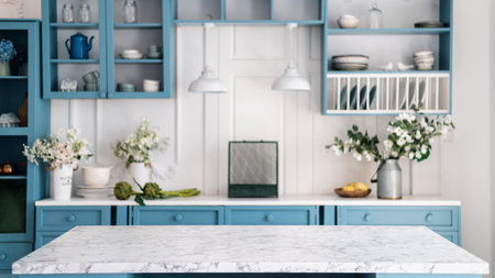 Empty marble kitchen island with clean surface in blue vintage kinchen in provence style. Dining table against blurred stylish furniture with drawers and kitchenware. Pendant lights hanging above.の写真素材