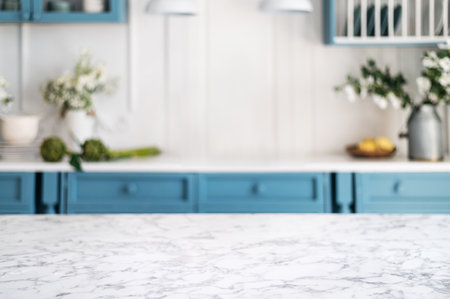 Empty and clean marble dining table in scandinavian kitchen. Modern monochrome interior with blue drawers on wooden furniture. Tablewear and vases with flowers.の写真素材