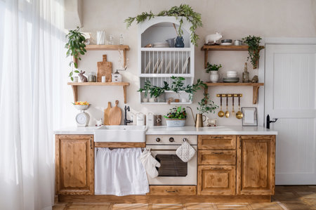 front view on home kitchen in scandinavian style, wooden cabinet furniture with white countertop, sink with faucet, electric oven, kitchenware and green plantsの写真素材