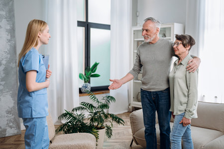 Concept of help, support and care. Happy elderly man and woman meeting medical nurse at home. Woman doctor visit senior couple, checking patient healthの写真素材