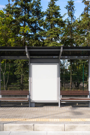 Vertical view of white template canvas on billboard for advertising at public transport stop. Copy space lightbox in metal frame on bus shelters with protective glassの写真素材