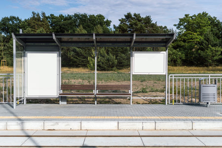 Bus station billboard with blank copy space screen for business advertising text or promotional content on bus shelters. Public transport stop with protective glass and white lightboxの写真素材