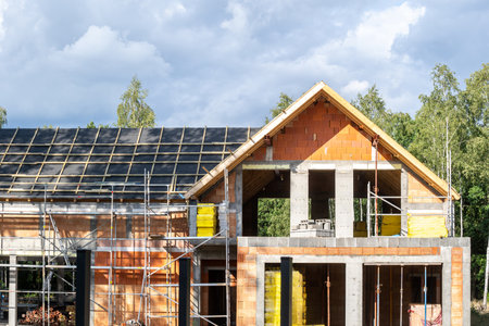 Investment in real estate. Residential property, housing project, roof reconstruction, renovation and repair process. Exterior of home under construction. Wooden rooftop with water protection membraneの写真素材