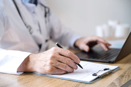 selective focus on doctor hand with pen filling patient medical chart at appointment in clinic....