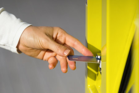 Close up of female hand holding and putting in debit card in card reader in bank machine. Checking account, changing password, withdrawing money in atmの写真素材