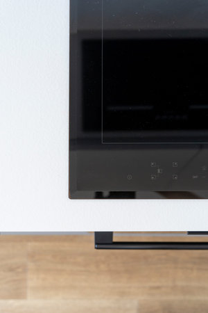 Flat lay view of black glass, ceramic induction hob with control panel on white wooden countertop. Built-in household appliance in modern kitchen. Electric stove for cooking. Advertising conceptの写真素材