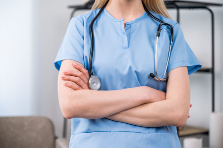 cropped shot of young confident woman physician in blue uniform standing with stethoscope and...