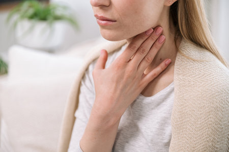 cropped shot of woman hand touching her neck, feeling throat sore. closeup of sick female with...