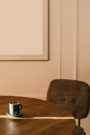 Espresso. Minimalist interior coffee shop with sunlight. Vertical shot of cup with hot black coffee on wooden table in modern room. Mug with fresh drink on wood desk in morning. Home office concept.の写真素材