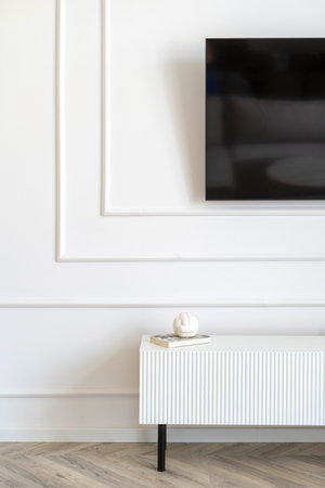 Living room with modern tv stand and decorated classic wall. Detail of interior at stylish apartment. Contemporary furniture and television display in houseの写真素材