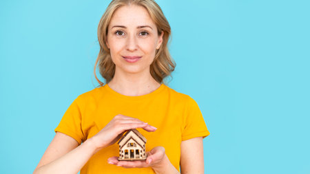 Real estate protection service, insurance concepts. Web banner view of professional female broker or realtor proposing renovated new home or apartment to client. Woman isolated on blue backgroundの写真素材