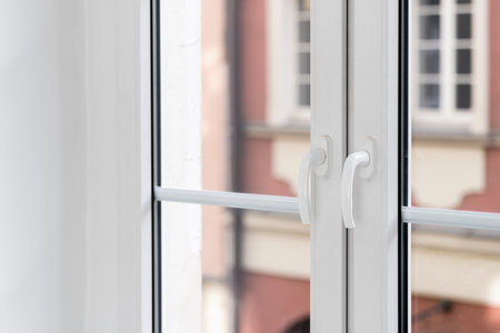 Closeup on pvc window with white frame, transparent glass and handles installed at modern apartment after renovation. Detail in interior.の写真素材