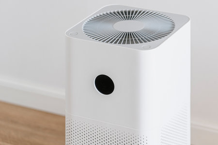 Air purifier with replaceable filter in white bedroom. Household appliance for cleaning, removing dust, allergy pollution or virus. Healthy, wellness, comfort life. Humidifier diffuser at homeの写真素材