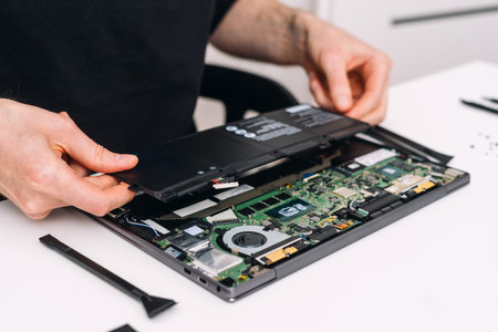 Professional technician change laptop battery. Computer repair service. Hardware, hard drive, hdd, motherboard damage and software diagnosticの写真素材