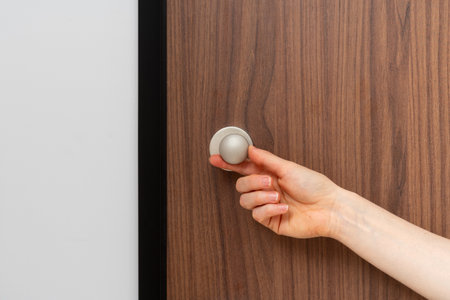 Cropped shot of woman using latch on front door closes the apartment from the inside. Concepts of protection, security and staying at home aloneの写真素材