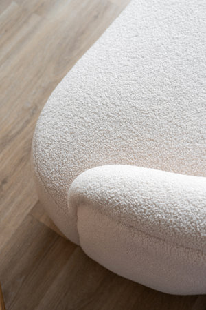 A close up shot of couch armrest with white plush fabric and textured surface. Part of stylish and soft elegant sofa in room, high angle viewの写真素材