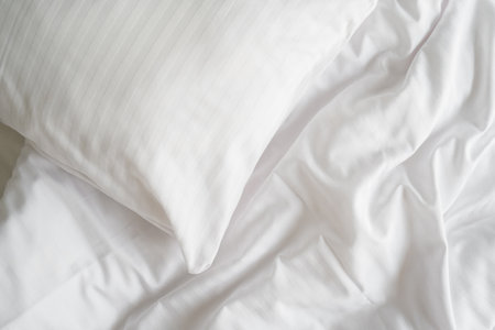 Top view of bed in hotel room with white pillowcase on memory foam pillow and clean and fresh bedsheets. Comfort sleeping at home, cozy bedroom, laundry day conceptsの写真素材