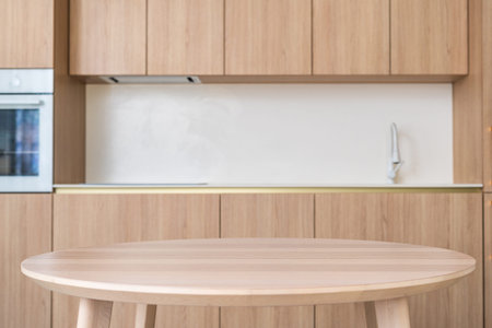 A contemporary kitchen features sleek wooden cabinets and dining table, creating a warm and inviting...