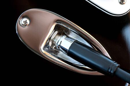 A section of a guitar showing the jack connection in macro.の写真素材